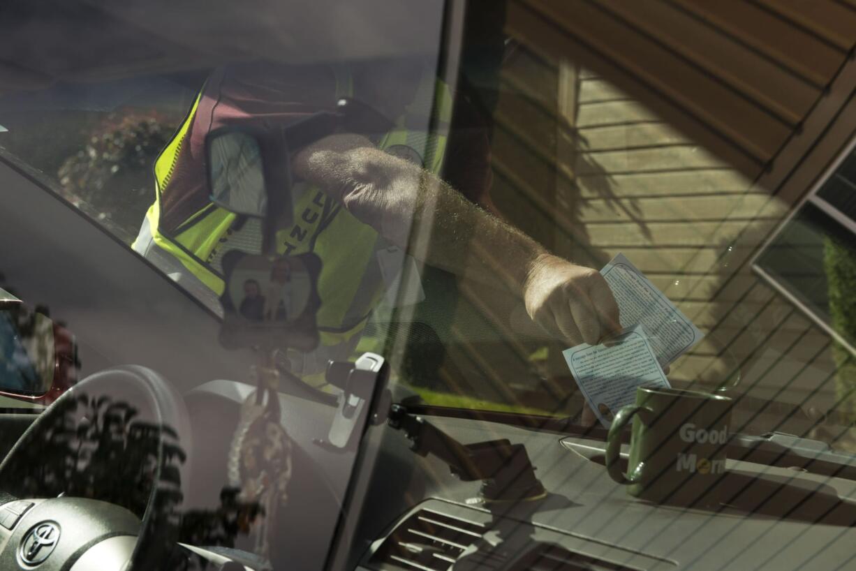 Scott Abels, a Neighbors On Watch volunteer, puts a notice on cars with out-of-state license plates in the Landover-Sharmel neighborhood in October.