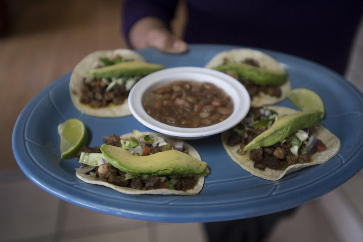 Morelia Mexican Grill owners Jennifer Ortiz, left, and Manuel Chairez display two of their popular taco choices, al pastor and carne asada. The restaurant has been in their family for five years, but the couple took over just this past year.