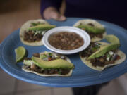 Morelia Mexican Grill owners Jennifer Ortiz, left, and Manuel Chairez display two of their popular taco choices, al pastor and carne asada. The restaurant has been in their family for five years, but the couple took over just this past year.