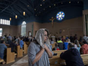 Esmeralda Herrera returns to her seat after receiving communion Wednesday during the All Saints’ Day Mass at Holy Redeemer Catholic Parish in east Vancouver.