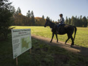 La Center resident Jane Sheaffer rides her horse, Millie, past a sign informing visitors of seasonal trail restrictions on Oct. 30 at Whipple Creek Regional Park in Ridgefield. As of Nov. 1, the park’s primitive trails are limited to foot traffic during the rainy season.