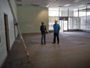 Construction project manager Chris Dery with the Vancouver Housing Authority, left, and housing rehab specialist Craig Frantz with the city of Vancouver, right, look over the front area of the former Fish and Wildlife Building in Vancouver on Wednesday, a space that the city intends to use as a day center for homeless people.