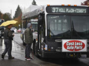 Passengers board a C-Tran bus Thursday at Fisher’s Landing Transit Center. The advertisements mounted on some of C-Tran’s fleet will be removed in the near future.