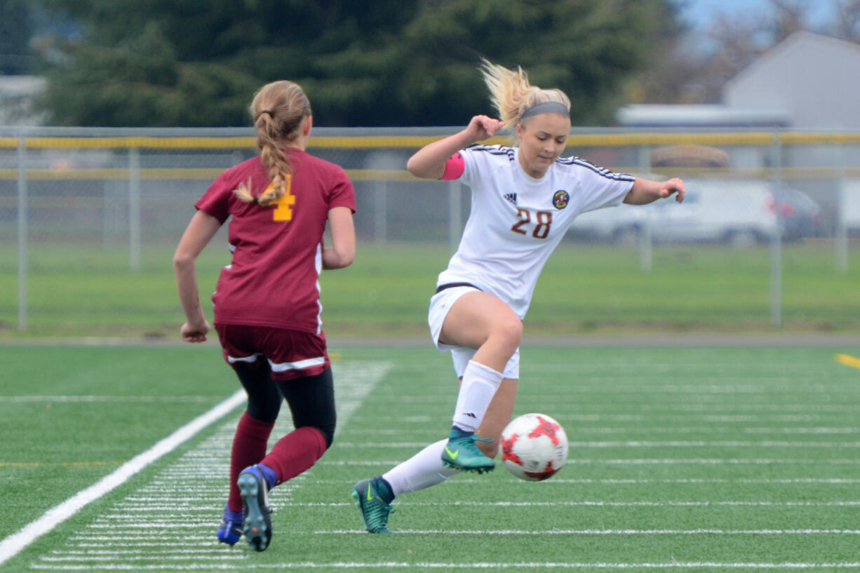 Prairie senior Kaylin Sperley keeps the ball from Capital junior Maddie Thompson during a 3A bi-district playoff game at Prairie High School on Saturday, November 4, 2017. Prairie beat Capital 2-1.