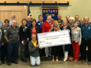 Battle Ground: Members of the Lewis River Rotary present a check for $20,000 to Ashley Homer, center, director of the Red Sweater Project, a nonprofit which looks to help kids in Tanzania continue education after elementary school.