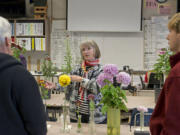 Elizabeth Adamson, Bill Wastradowski, left, and Micah Black talk shop about chrysanthemums Sunday at Hudson’s Bay High School, during the Vancouver Chrysanthemum Society’s annual flower show.