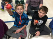 Five Corners: Silver Star Elementary School students Aubyn Broer, left, and Caiden Kinder take bites out of apples as part of the school’s apple crunch to kick off its Harvest of the Month campaign.