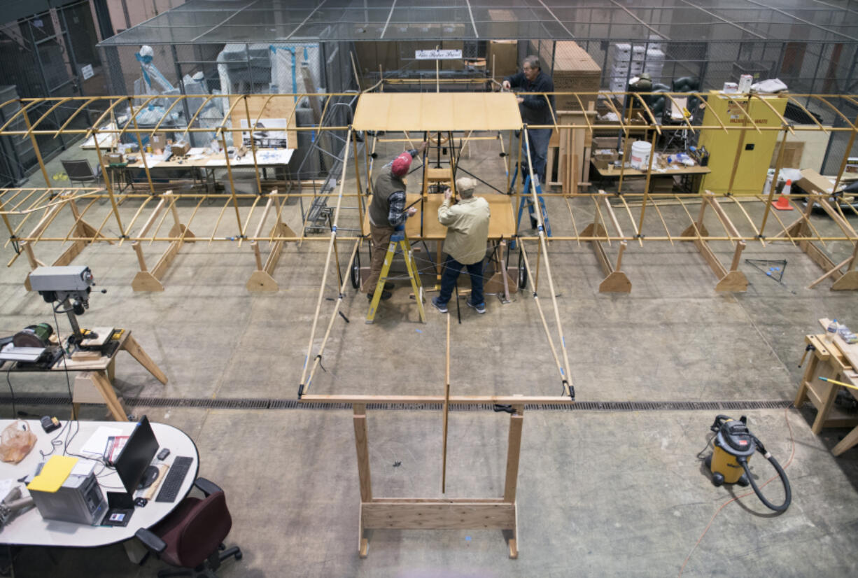 Park Service volunteers Dennis Darby of Portland, from left, John Sutter of Portland and Don Erickson of Washougal work on the full-scale replica of a 1912 Curtiss Pusher at Fort Vancouver on Nov. 9. It is a replica of the Curtiss Pusher that flew from the roof of the Multnomah Hotel in Portland to Vancouver Barracks in 1912.