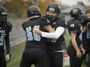 Hockinson’s Robert Flores (56) and Ki Haden (89) hug each other following a touchdown during the class 2A state playoffs against Pullman at Battle Ground District Stadium, Friday November 10, 2017.