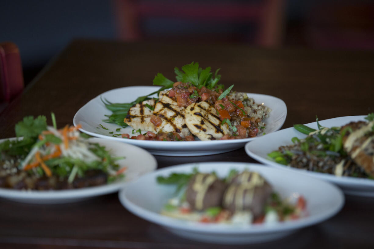 Grilled medallions of chicken breast, clockwise from top center, are served with pan-fried panko and sesame breaded pork tenderloin, house-made Angus beef meatballs and Cantonese-style caramelized pork belly.