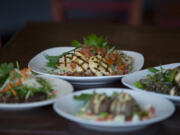 Grilled medallions of chicken breast, clockwise from top center, are served with pan-fried panko and sesame breaded pork tenderloin, house-made Angus beef meatballs and Cantonese-style caramelized pork belly.