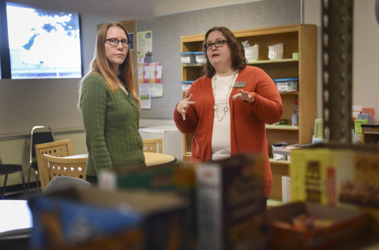 Nova Gump, interim program assistant at the Penguin Pantry at Clark College, left, consults with Natalie M. Shank, assistant director of student care and community standards at Clark College, about food items in the pantry. The Penguin Pantry opened this summer to support currently enrolled Clark College students.