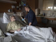 Vancouver resident William Gilbert, left, shares a moment with registered nurse Mandy Herrera during his stay Nov. 13 at Legacy Salmon Creek Medical Center. Nurses in two units of the hospital implemented a no-cellphone policy in patient care areas that is now spreading to the rest of the hospital. Patient satisfaction scores have increased since the policy was implemented.