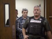 Brent Luyster, center, makes his way into the courtroom during his triple aggravated murder trial in Clark County Superior Court on Monday morning, Nov. 13, 2017.