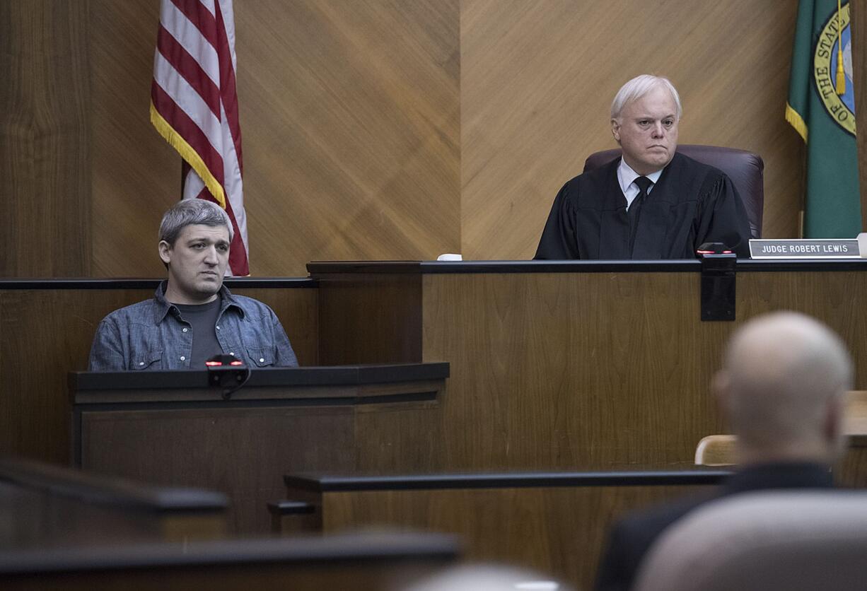 Brent Luyster, left, takes the stand during his triple aggravated murder trial as Judge Robert Lewis listens in Clark County Superior Court on Tuesday morning.