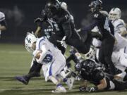 Hockinson nose guard Nathan Balderas (71) and linebacker Sawyer Racanelli (11) tackle Liberty wide receiver Reilly Larson in the 2A state football quarterfinals.