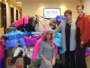 Vancouver Mall: Remax agents, from left, Pam Moore, Dominique Roark and Lori Anderson-Benson with the 200 coats collected for Open House Ministries, 50 of which were new coats purchased by Anderson-Benson.