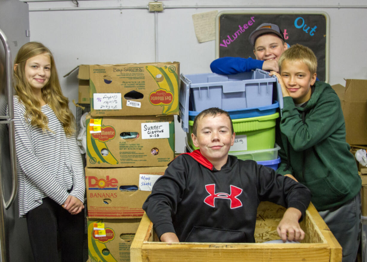 Woodland: Woodland Middle School seventh-graders, from left, Dasha Vasilenko, Blake Smith, Tyson Lindberg and Ian Peterson processing donations and restocking shelves at the Woodland Action Center as part of a volunteering project through their leadership class.