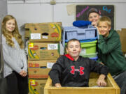 Woodland: Woodland Middle School seventh-graders, from left, Dasha Vasilenko, Blake Smith, Tyson Lindberg and Ian Peterson processing donations and restocking shelves at the Woodland Action Center as part of a volunteering project through their leadership class.