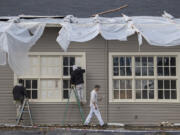 Nathan Vernon, right, walks toward his work site Monday morning as a crew from Pro Paint Northwest renovates the former motor repair shop at Fort Vancouver National Historic Site. Built in 1919, it is one of five buildings in the East Barracks getting exterior makeovers.