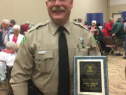 Clark County sheriff’s Deputy Tim Gosch and his award from the Washington State Grange organization honoring him as its Policeman of the Year in late June.