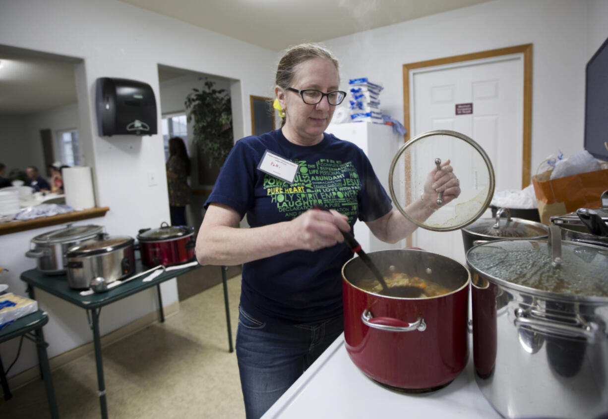 Patricia Peacher stirs soup at her first Ladle of Love event Sunday at the Woodland Community Center. Peacher started the event to feed the hungry in her community, something she has felt a calling to do for the last few years.