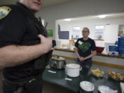 Patricia Peacher offers soup to a police officer at her first Ladle of Love event on Sunday.