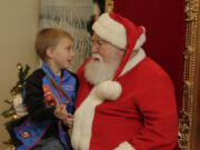 Five-year-old Owen McCart of Vancouver, left, makes his case to Santa Claus at the Vancouver Farmers Market’s Holiday Market Sunday afternoon.