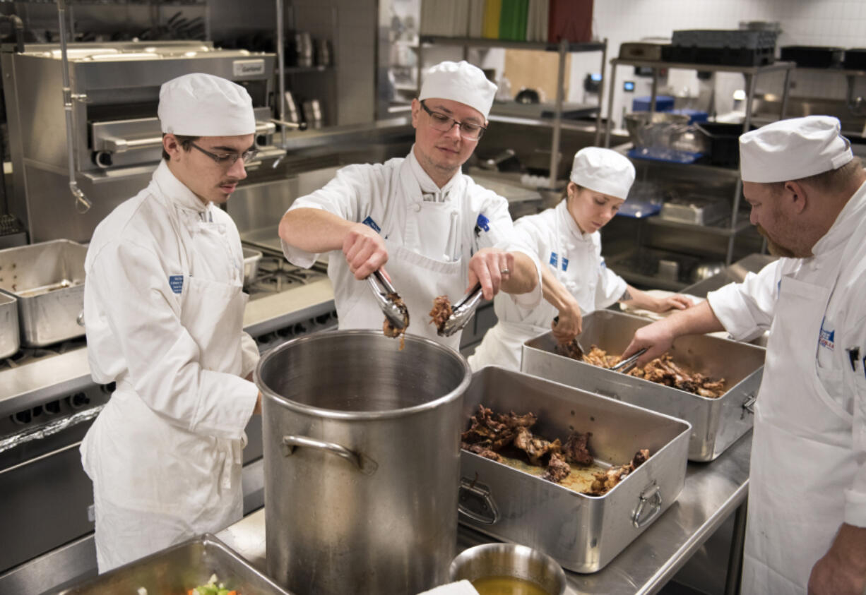 Culinary students Daniel Templin of Woodland, left, Aaron Welton of Battle Ground, Arryn Sayer of Castle Rock, and William Hobson of Vancouver, prepare chicken stock during their morning class at Clark College’s Tod and Maxine McClaskey Culinary Institute in Vancouver on Tuesday.