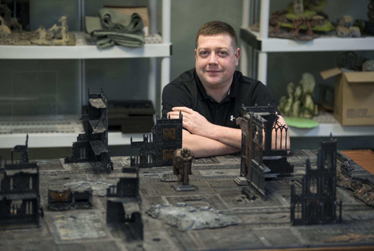 James Omelina sits next to a game of Warhammer 40,000 at Mythic Realm Games in Salmon Creek. Omelina designs increasingly popular escape rooms for Mythic Escapes, with a fourth escape room planned at Mythic Realm Games.