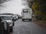 A FedEx truck passes a long line of parked cars Thursday along East Anderson Street, which has become increasingly congested from people parking along the road instead of paying for parking downtown. That congestion blocked truck access through the area until October, when the city of Vancouver restricted parking to one side.