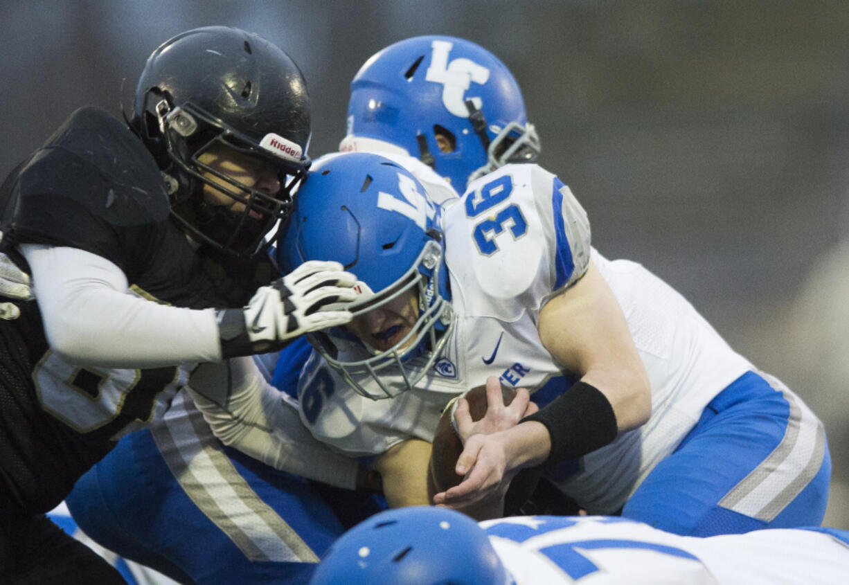 La Center’s Wyatt Dodson is tackled by Meridian’s Manny Sabalza on Saturday, Nov. 25, at Civic Stadium in Bellingham.