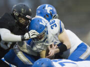 La Center’s Wyatt Dodson is tackled by Meridian’s Manny Sabalza on Saturday, Nov. 25, at Civic Stadium in Bellingham.