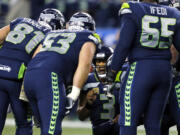 Seattle Seahawks quarterback Russell Wilson (3) leads his team in a huddle against the Atlanta Falcons in the first half of an NFL football game, Monday, Nov. 20, 2017, in Seattle.