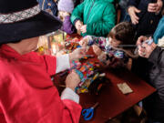 Four-year-old Kinsey Fleming, center, Beaverton, Ore., makes a tassle during the Christmas at the Fort celebration in 2016.
