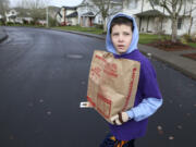 Zachary Borghello carries donated food for the Autism Serves Kids Care Club during Walk & Knock in 2016.