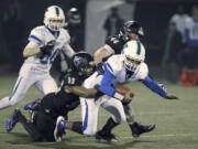 Hockinson defenders Tony Richardson (35) and Colton Wheeler (44) tackle Liberty quarterback Samuel Brown in the 2A state football quarterfinals.