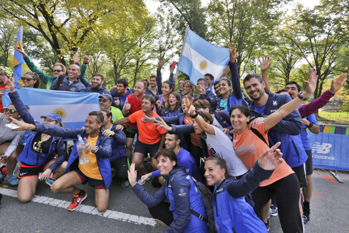 A group of runners from Argentina pose for photos with their country's flag, near the finish of the New York City Marathon, in New York's Central Park, Friday, Nov. 3, 2017. New York City police say they're prepared with increased security for the marathon this weekend, days after eight people were killed not far from the World Trade Center in a terrorist attack when a man driving a rented truck mowed people down on a bicycle path.