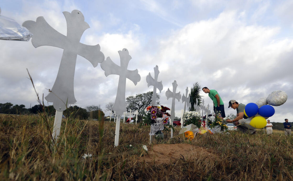 Kevin Blomstrum, left, and Kyle Dahlberg visit a makeshift memorial for victims near the scene of a shooting at the First Baptist Church of Sutherland Springs, Tuesday, Nov. 7, 2017, in Sutherland Springs, Texas. A man opened fire inside the church in the small South Texas community on Sunday, killing more than two dozen and injuring others.