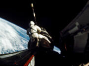 In this September 1966 photo provided by NASA, astronaut Richard F. Gordon Jr., pilot for the Gemini XI spaceflight, sits astride the spacecraft during a spacewalk, while attaching a tether from the Gemini capsule to the Agena vehicle. This picture was taken over the Atlantic Ocean at approximately 160 nautical miles above Earth. Gordon, one of a dozen men who flew around the moon but didn’t land there, has died, NASA announced Tuesday, Nov. 7, 2017. He was 88.