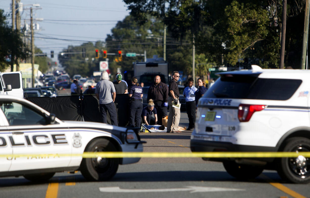 Law enforcement agents investigate a fatal shooting in the Seminole Heights neighborhood in Tampa, Fla., Tuesday, Nov. 14, 2017.  Police searched the neighborhood after a person was shot dead, possibly by a serial killer. Spokesman Steve Hegarty said detectives can't immediately say whether the shooting is related to last month's 10-day spree where three people were slain, but officers are treating it like it is.