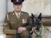 Cpl. Daniel Hatley poses Nov. 17 with Mali, recipient of the Dickin medal for animal bravery.