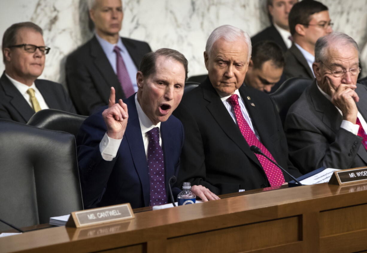 Sen. Ron Wyden, D-Ore., left, the top Democrat on the Senate Finance Committee, criticizes the Republican tax reform plan while Chairman Orrin Hatch, R-Utah, center, and Sen. Chuck Grassley, R-Iowa, far right, listen to his opening statement as the panel begins work overhauling the nation’s tax code, on Capitol Hill in Washington on Monday. The legislation in the House and Senate carries high political stakes for President Donald Trump and Republican leaders in Congress, who view passage of tax cuts as critical to the GOP’s success at the polls next year. (AP Photo/J.