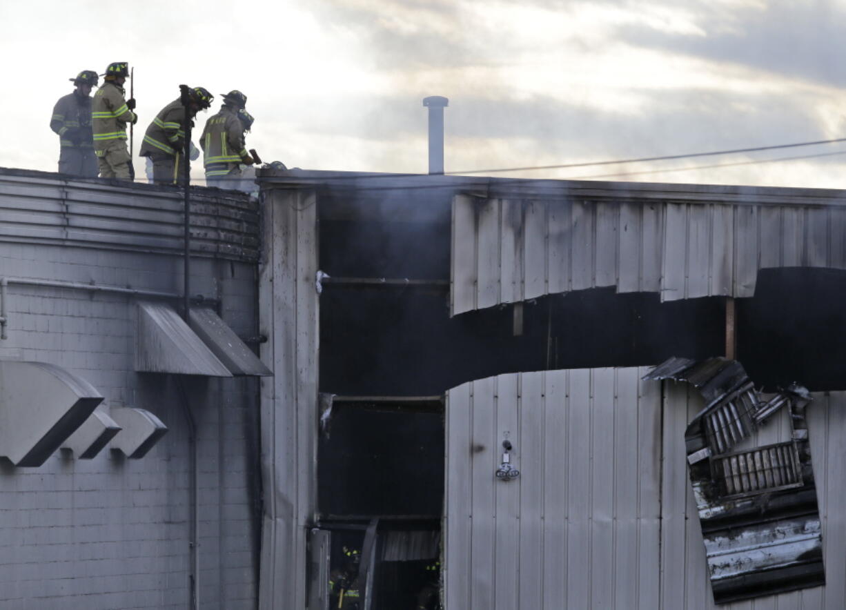 Firefighters work at the scene of a factory fire in New Windsor, N.Y., on Monday. Authorities say two explosions and a fire at the Verla International cosmetics factory in the Hudson Valley about an hour north of New York City have left multiple people injured, including firefighters caught in the second blast.