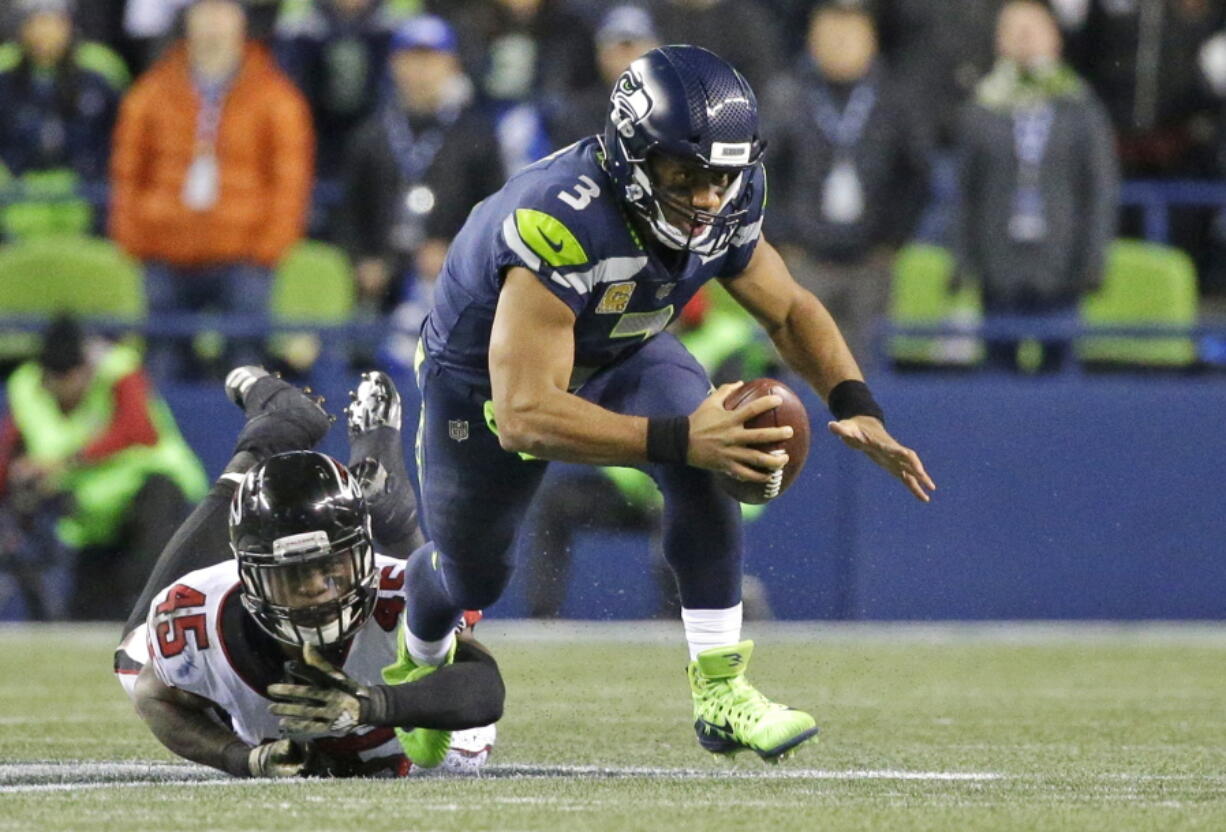 Seattle Seahawks quarterback Russell Wilson (3) is tripped up by Atlanta Falcons middle linebacker Deion Jones (45) as he scrambles in the second half of an NFL football game, Monday, Nov. 20, 2017, in Seattle. The Falcons won 34-31. (AP Photo/Ted S.