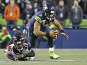 Seattle Seahawks quarterback Russell Wilson (3) is tripped up by Atlanta Falcons middle linebacker Deion Jones (45) as he scrambles in the second half of an NFL football game, Monday, Nov. 20, 2017, in Seattle. The Falcons won 34-31. (AP Photo/Ted S.