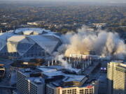 The Georgia Dome is destroyed in a scheduled implosion next to its replacement the Mercedes-Benz Stadium, left, Monday, Nov. 20, 2017, in Atlanta. The dome was not only the former home of the Atlanta Falcons but also the site of two Super Bowls, 1996 Olympics Games events and NCAA basketball tournaments among other major events.