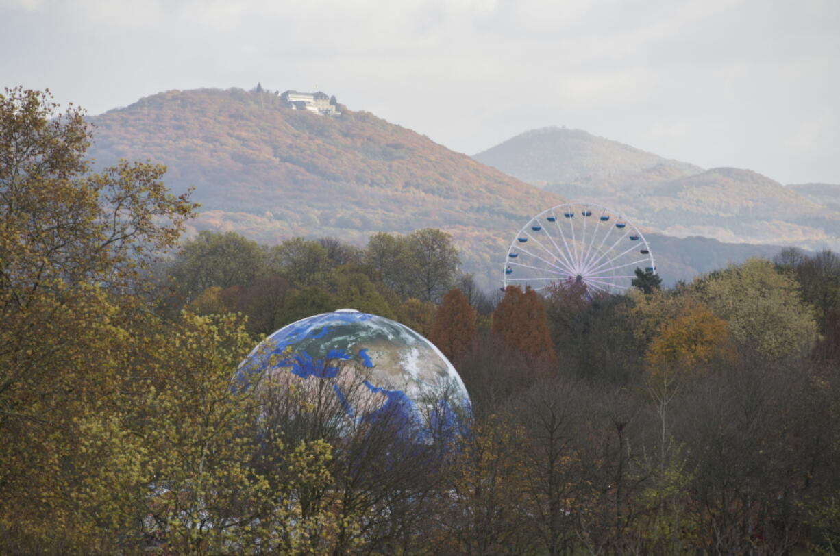 A globe and a Ferris wheel stand in the forest Monday near Bonn, Germany. The U.N. Climate Conference takes place in Bonn, Germany through Friday.