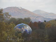 A globe and a Ferris wheel stand in the forest Monday near Bonn, Germany. The U.N. Climate Conference takes place in Bonn, Germany through Friday.