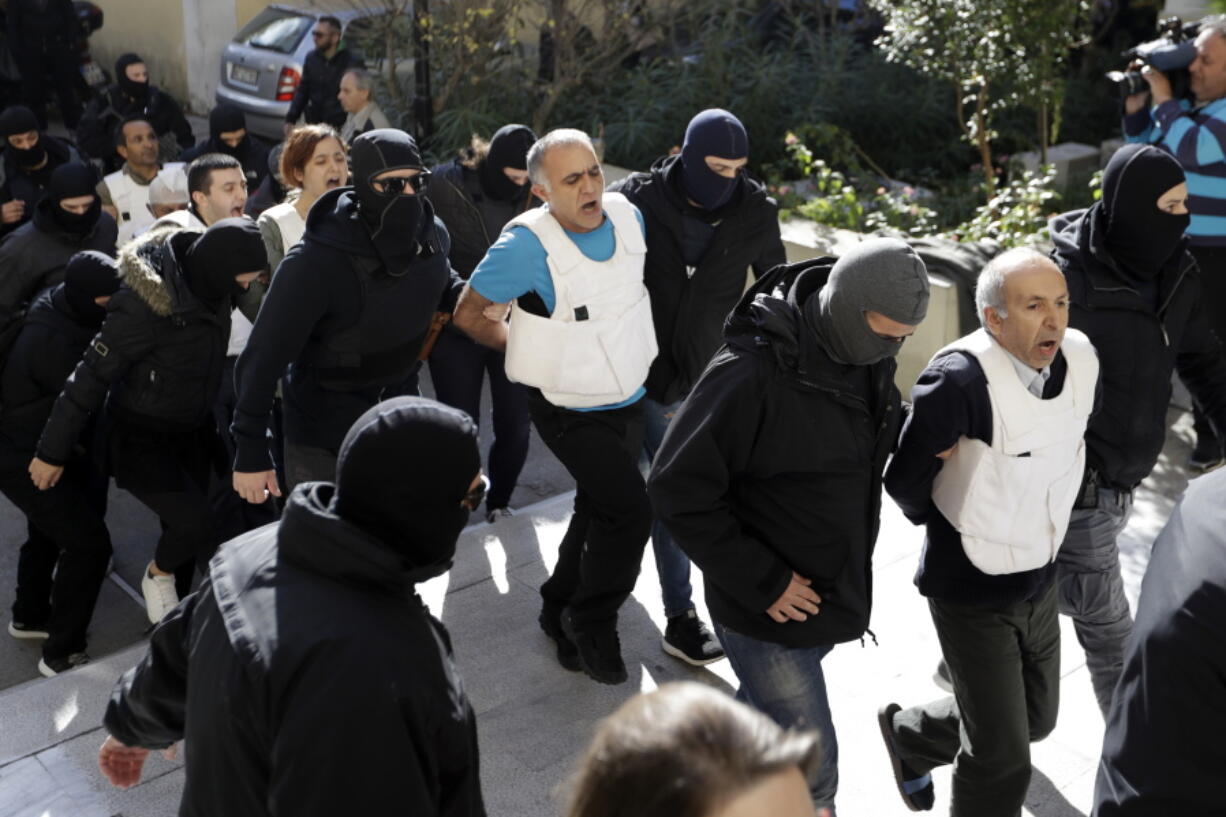 Turks escorted by anti-terror police arrive at a court in Athens on Wednesday. Greek counter-terrorism police detained nine Turks in Athens on Tuesday in an investigation into Turkish leftist militant groups, ahead of a scheduled visit next month by Turkey’s President Recep Tayyip Erdogan.